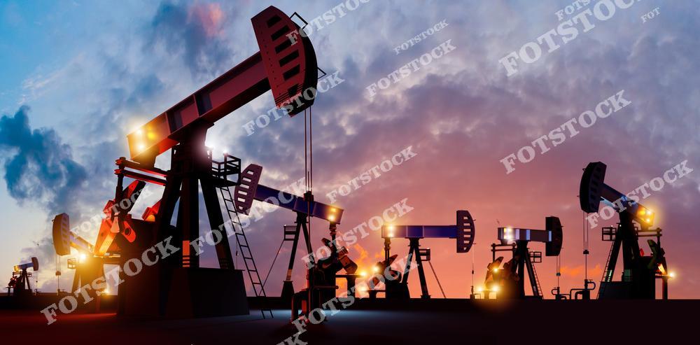На фотографии изображены нефтяные качалки, которые активно работают на нефтяном месторождении. Их силуэты выделяются на фоне красочного заката, создавая впечатляющий промышленный пейзаж. Изображение подчеркивает важность нефтяной промышленности и энергоресурсов для современной экономики.